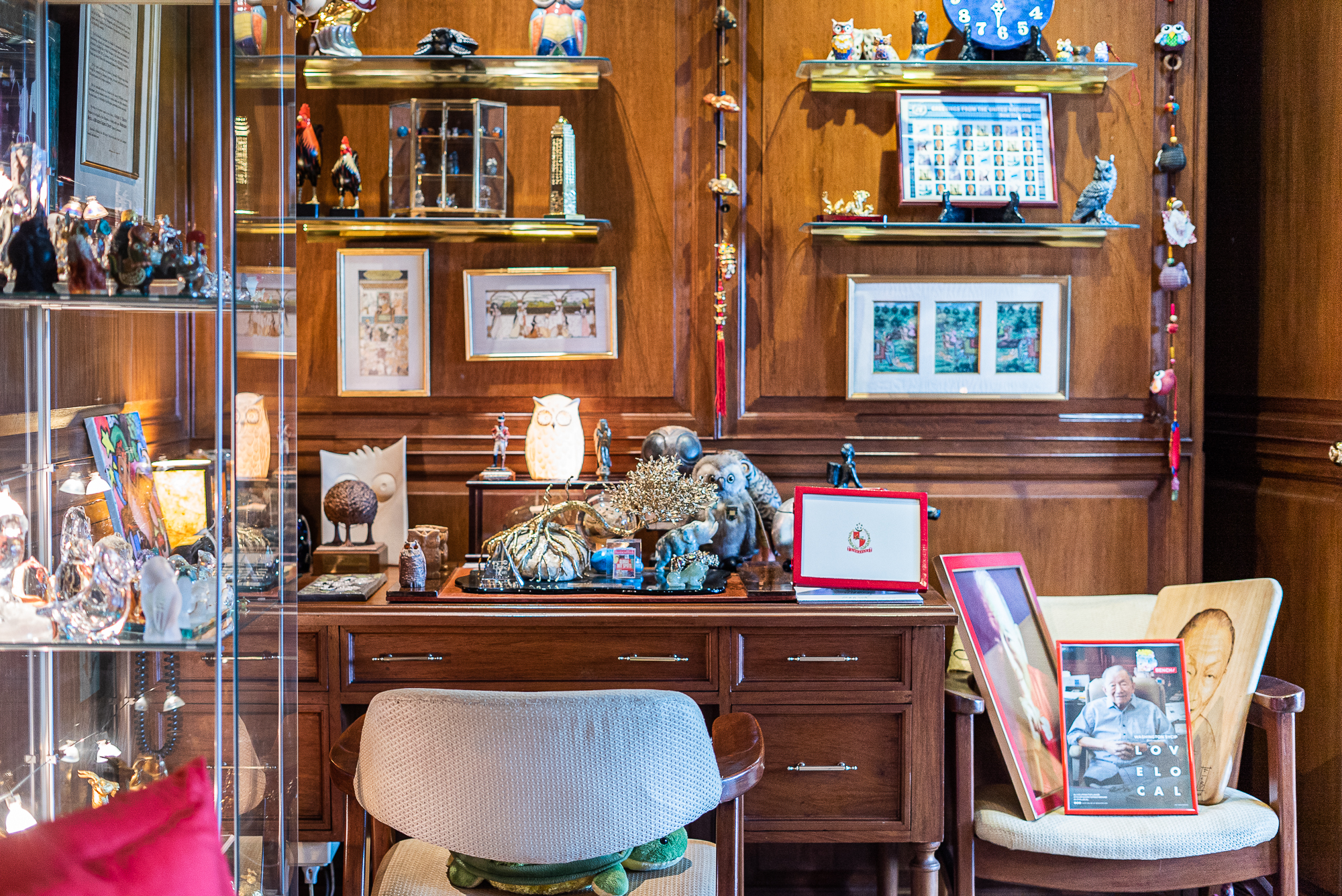 This desk was hardly ever used as one. It became another table to hold more photos and knickknacks. The glass case was a gift from an artist friend who wanted to organize this corner of his office.